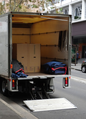 The back of a mover's truck parked on a city street - NQ Car & Truck Rentals